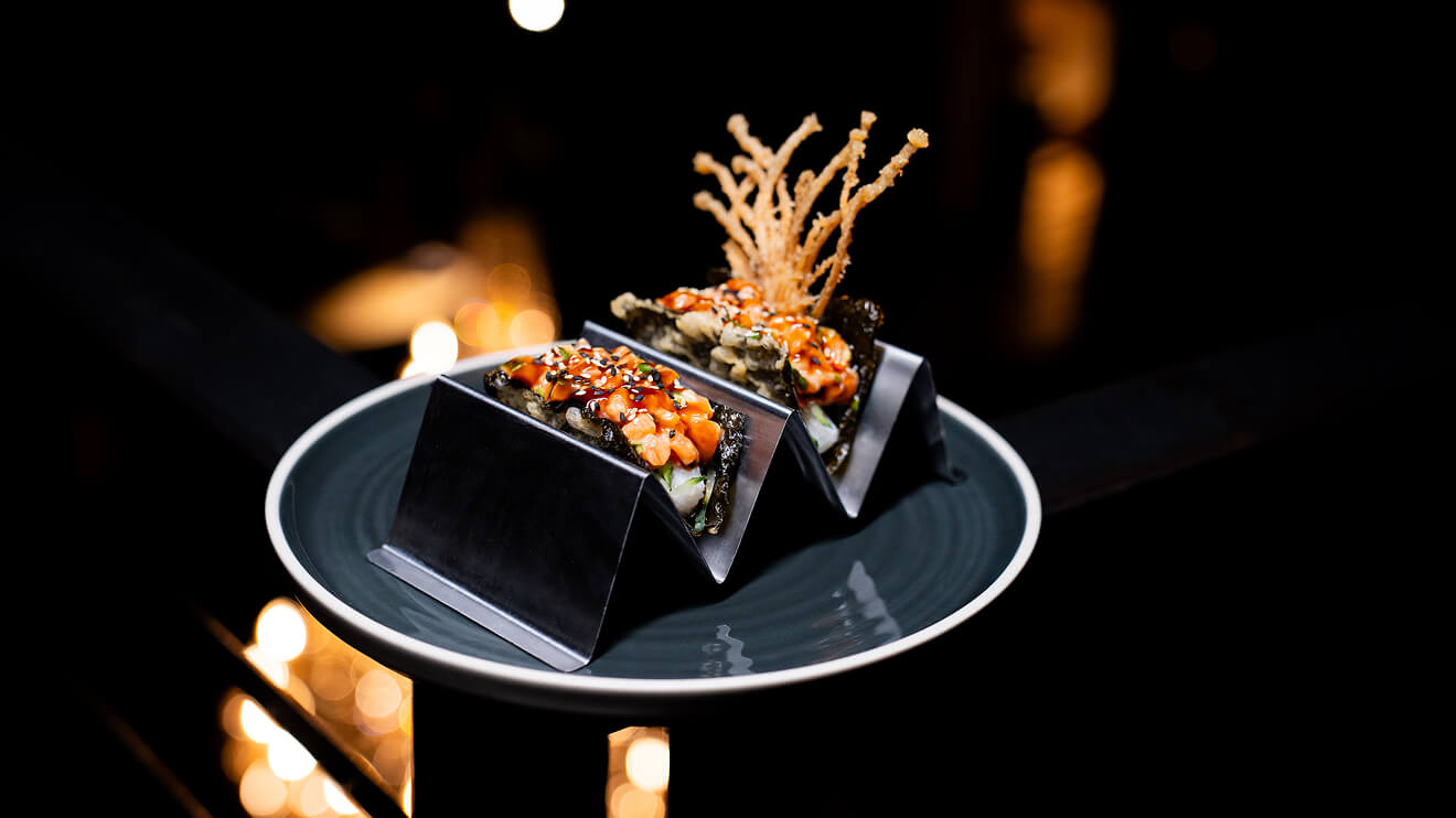 Fabrika's signature Salmon Sushi Tacos served on a metal tray, illustrating unique menu options for a special dinner out in Philadelphia.
